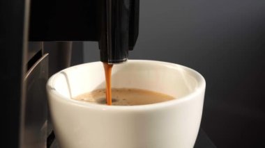 Modern kahve makinesi Americano 'yu beyaz fincana çeviriyor.
