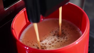 Modern kahve makinesi beyaz fincana espresso yapıyor, yukarıdan görüyor. Yakın çekim.