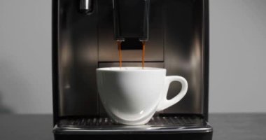 Modern kahve makinesi beyaz fincana espresso yapıyor, yakın plan.