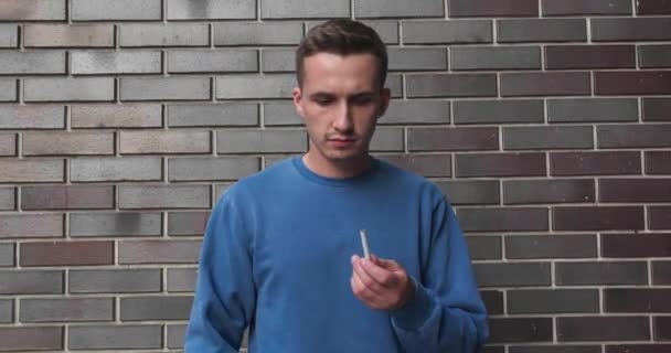 Man Bryter Cigarett Och Slutar Röka Nära Svart Tegelvägg — Stockvideo