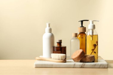 Tahta masada bej arka planda farklı banyo aksesuarları. Metin için boşluk