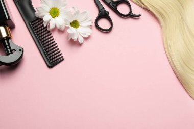 Farklı kuaför araçları ve pembe arka planda çiçekler ile düz konum, metin için boşluk