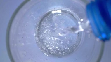 Açık mavi arka planda karbonatlı su döküp limon dilimlerini cama döküyorum.