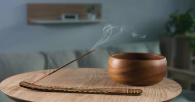 Odasındaki ahşap masaya tütsülenmiş tutucu.