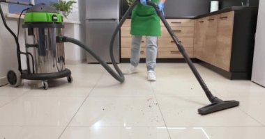 Temizlikçi ofis mutfağını süpürüyor, yakın plan. Temizlik servisi