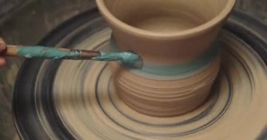 Potter kil vazoyu fırlatma çarkında dekore ediyor, yakın plan. Seramik sanat