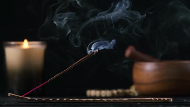 Holder with smoldering incense stick on black wooden table indoors
