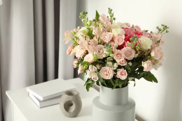 Beautiful bouquet of fresh flowers in vase on white table indoors, space for text