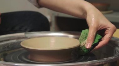 Potter atarken sünger kullanıyor, yakın plan.