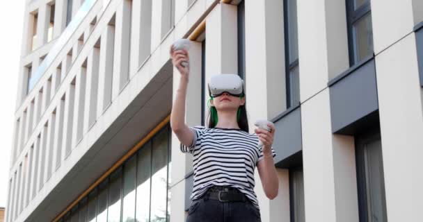 Experimentează Femeie Tânără Căști Realitate Virtuală Controlere Mișcare Apropierea Clădirii — Videoclip de stoc