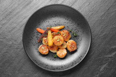 Koyu gri desenli masada nefis kızarmış deniz tarakları.