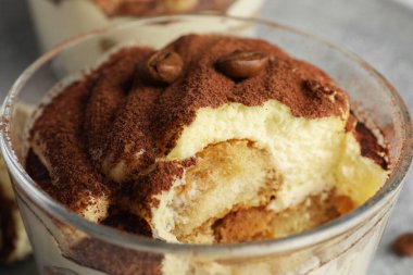 Bardakta nefis tiramisu ve masada kahve çekirdekleri, yakın plan.