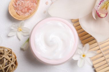 Beyaz masa üzerinde kozmetik ürünleri ve çiçekleri olan güzel bir spa kompozisyonu.