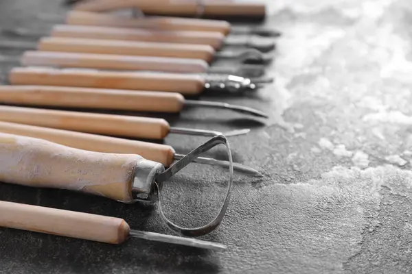 Set of different clay crafting tools on grey table, closeup. Space for text
