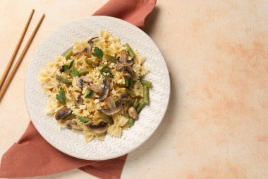 Mantarlı vejetaryen makarna, maydanoz, çalı fasulyesi ve peynir portakal dokulu masa, üst manzara. Metin için boşluk