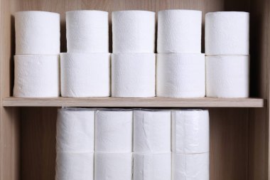 Tahta raflarda istiflenmiş tuvalet kağıdı ruloları