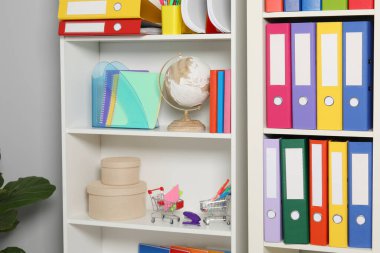 Renkli klasör ofis dizinleri ve raf ünitesi içerisindeki diğer kırtasiyeler