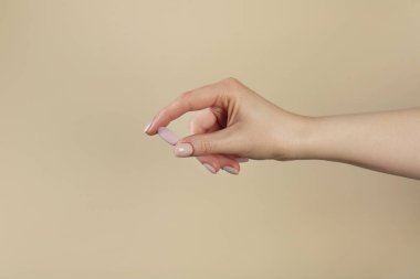 Elinde koyu bej arka planda vitamin hapı tutan kadın, yakın plan. Sağlık takviyesi