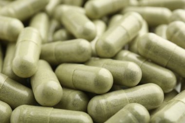Arkaplan olarak açık yeşil vitamin kapsülleri, yakın plan