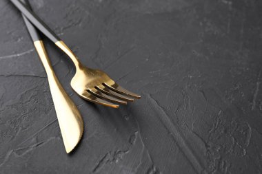 Siyah masaya güzel bir çatal bıçak seti, yakın plan. Metin için boşluk