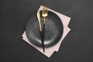 Siyah masasında parlak çatal bıçak takımı olan şık bir ortam.