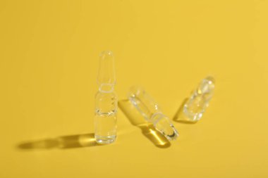 Sarı zemin üzerinde sıvı bulunan cam ampuller