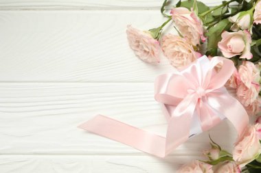 Anneler Günün kutlu olsun. Güzel güller ve hediye kutusu beyaz ahşap masa üzerinde, düz yatıyordu. Metin için boşluk