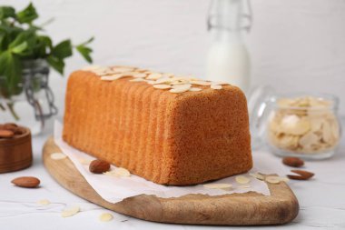 Beyaz desenli masada taze badem gevreği ve fındıklı kek, yakın plan.