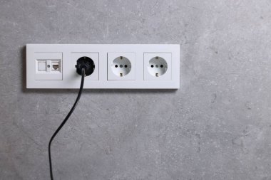 Gri duvarda prizler ve elektrik prizleri, metin için boşluk
