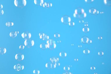 Açık mavi arkaplanda güzel şeffaf sabun köpükleri