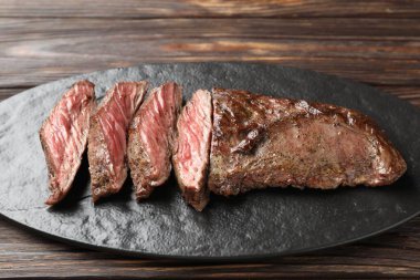 Ahşap masada lezzetli ızgara et parçaları.