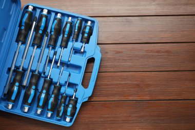 Tahta masadaki açık alet kutusunda tornavida seti, üst manzara. Metin için boşluk