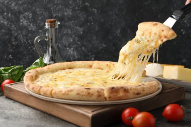 Gri masada lezzetli peynirli pizza yiyordum.
