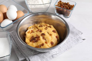 Kuru üzümlü hamur ve beyaz ahşap masa malzemeleri.