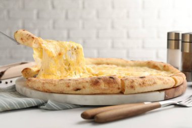 Beyaz masada lezzetli peynirli pizza yiyordum.