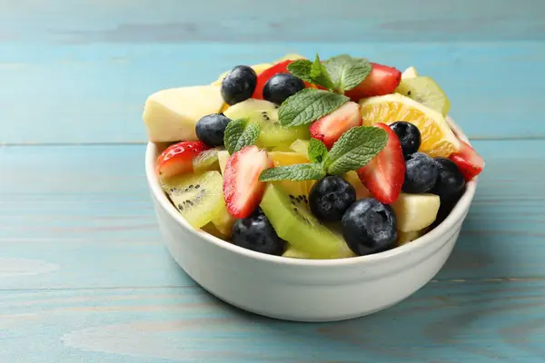 Tasty Fruit Salad Bowl Light Blue Wooden Table Closeup Space — Stock Photo, Image