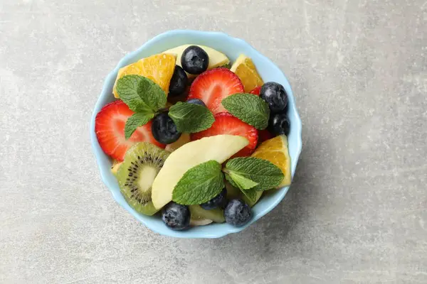 Tasty Fruit Salad Bowl Gray Textured Table Top View — Stock Photo, Image