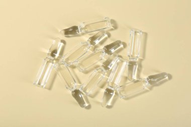 Bej arka planda sıvı bulunan cam ampuller, üst görünüm