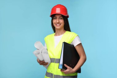 Açık mavi arkaplan üzerinde taslak ve klasör olan sert şapkalı mimar