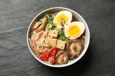 Erişte çorbası. Bir kase lezzetli ramen ve siyah masa, üst manzara.