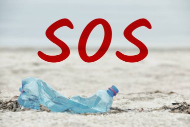 Kelime SOS ve plajda kullanılan plastik şişe. Geri dönüşüm sorunu