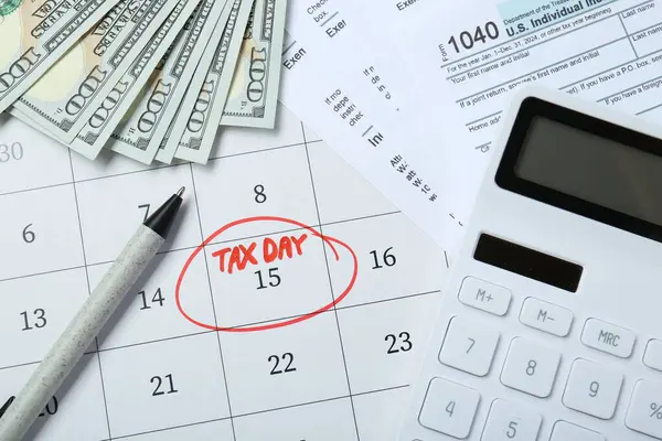 Calendar with date reminder about tax day, documents, pen, calculator and money, top view