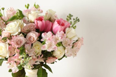 Beyaz duvarın yanında güzel bir buket taze çiçek, yazı için yer var.