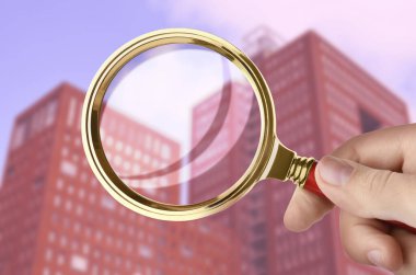 Bir kadın büyüteçle şehri tarıyor, yakın plan. Apartman ara