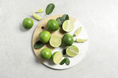 Taze kireç ve yapraklar ışık masasında, üst görünümde.