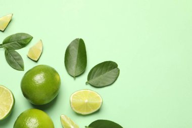 Açık yeşil zemin üzerinde yaprakları olan taze, olgun limonlar.