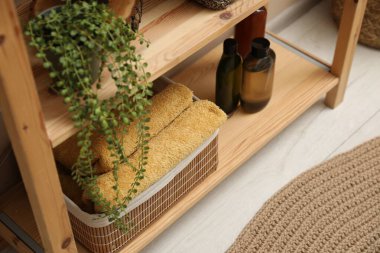 Depodaki yumuşak havlular, içerideki raflardaki bitki ve şişeler.