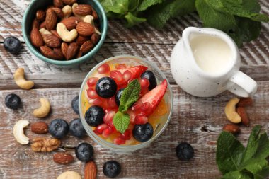 Lezzetli meyve salatası, taze böğürtlen, nane ve fındık, ahşap masa, düz uzanma