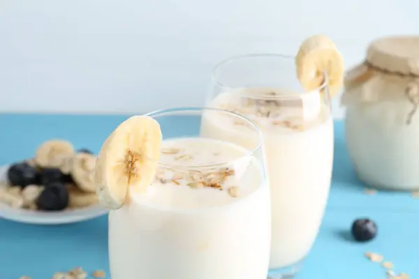 Ízletes Joghurt Szemüvegben Zab Banán Áfonya Világoskék Asztalon Közelkép — Stock Fotó