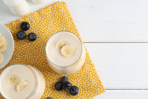 Tasty Yogurt Banana Blueberries White Wooden Table Top View Space — Stock Photo, Image